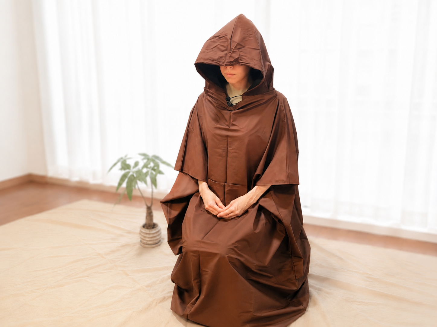 フード付きポリウレタンマントを羽織る女性